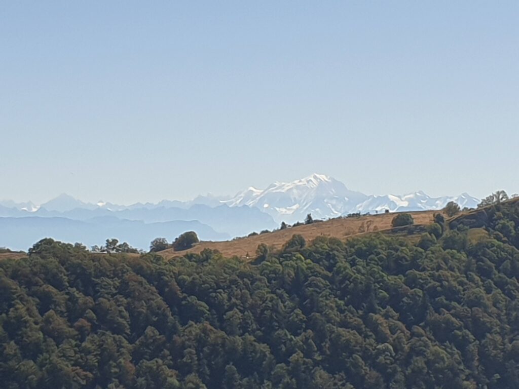 View on the Mont Blanc and the Alps in the background with the Montagne du Fier in front of it, and a blue sky with clouds