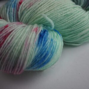 close up of a light green, blue and scarlet hand dyed yarn