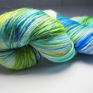 hand dyed yarn skein in blue and green with yellow and brown speckles